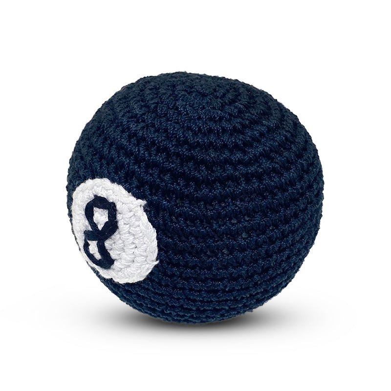 Dark blue crochet 8-ball toy with off-center white number 8 patch, angled view