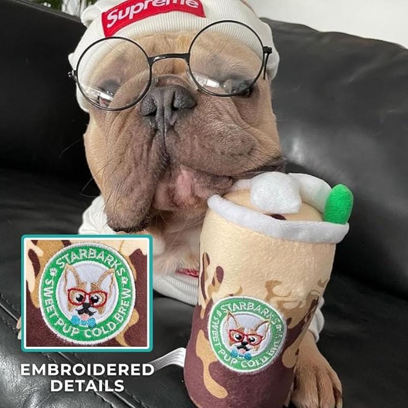 Plush cold brew cup dog toy held by dog, brown and cream fabric with stitched pup logo