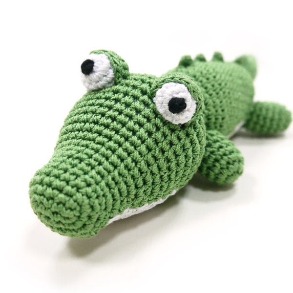 Crochet alligator plush head with black eyes and white eye patches, green body.
