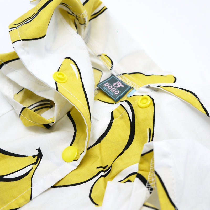 Close-up of banana-print pet shirt with yellow buttons and a fabric brand tag