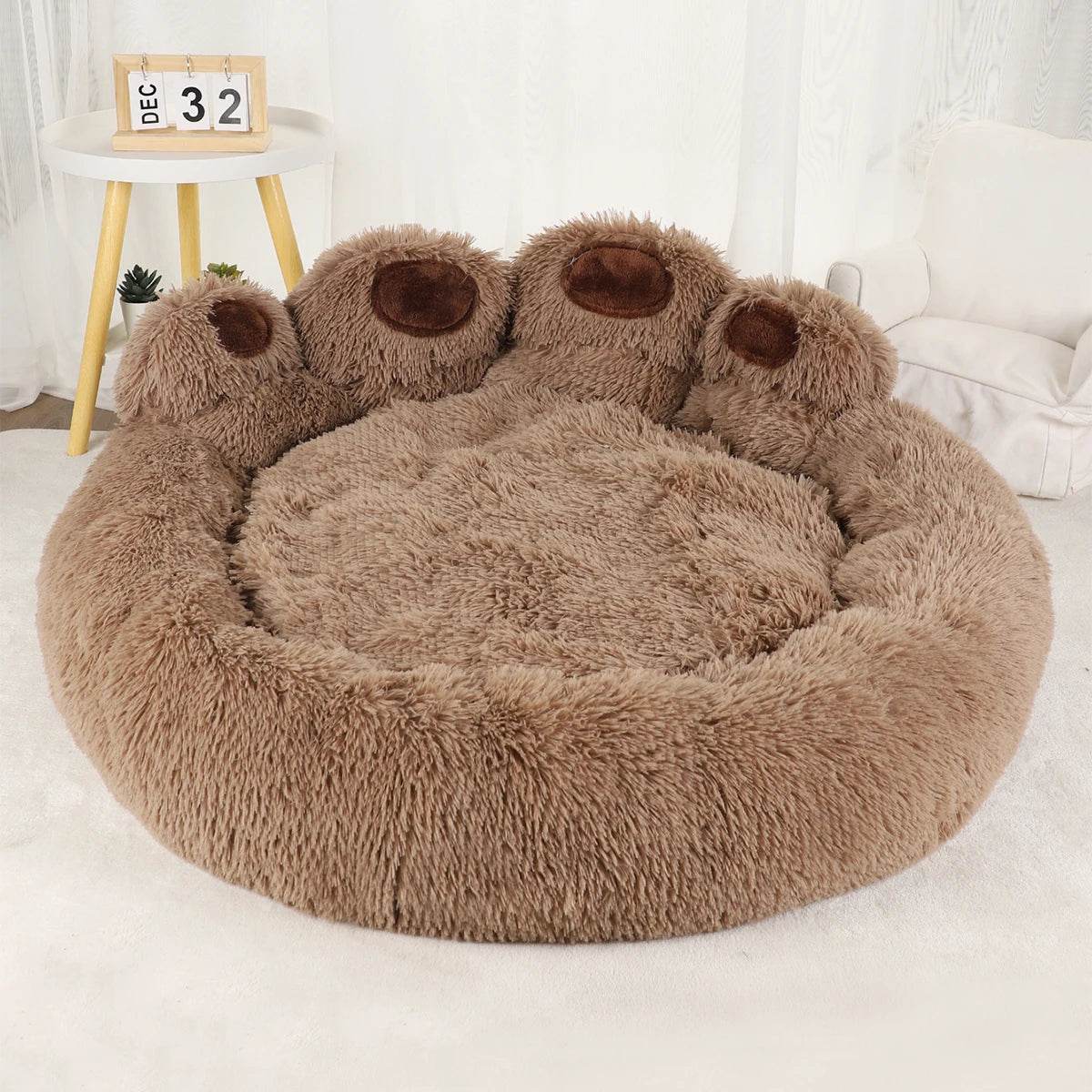 Brown round plush pet sofa bed with raised edges and paw-shaped bolster accents