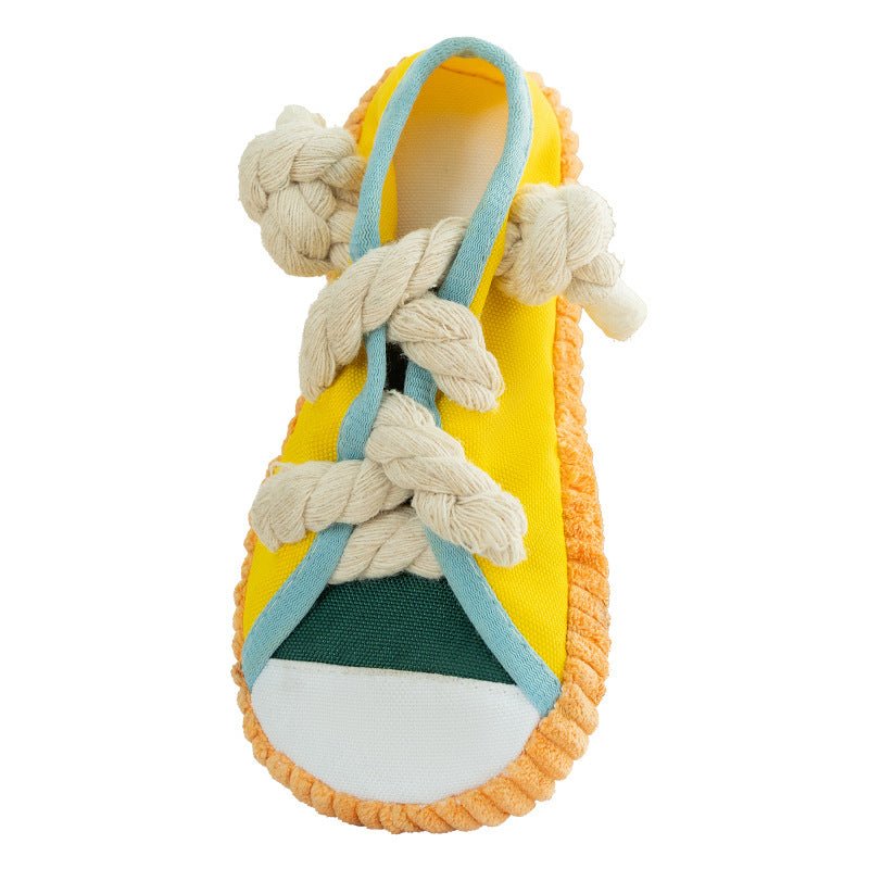 Shoe-shaped dog chew toy with braided rope laces, yellow fabric and green toe panel.