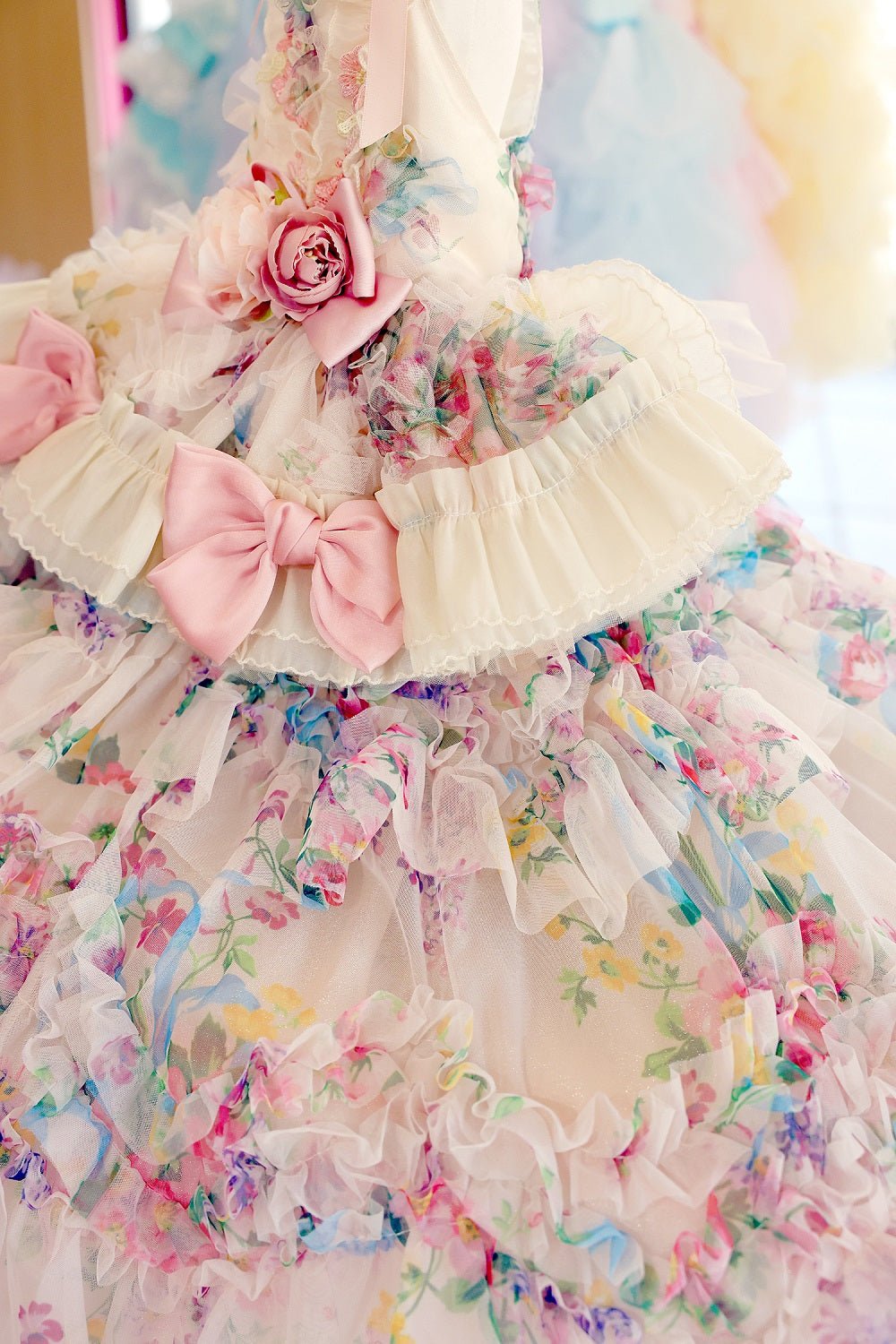 Close-up of floral pastel ruffle dog dress with pink bows and rose detail