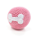 Pink crochet bone ball toy, front view with white bone applique.