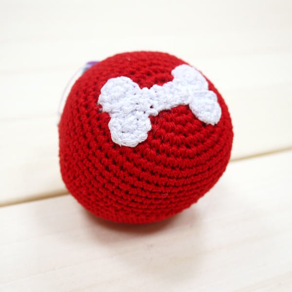 Red crochet bone ball toy with white bone applique on the front.