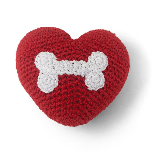 Red crocheted heart toy with white bone-shaped applique on front.