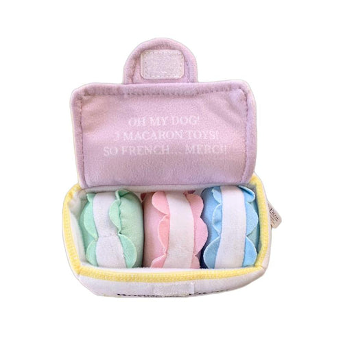 Lavender plush macaron squeaky toy set in open zip pouch with pastel macarons.