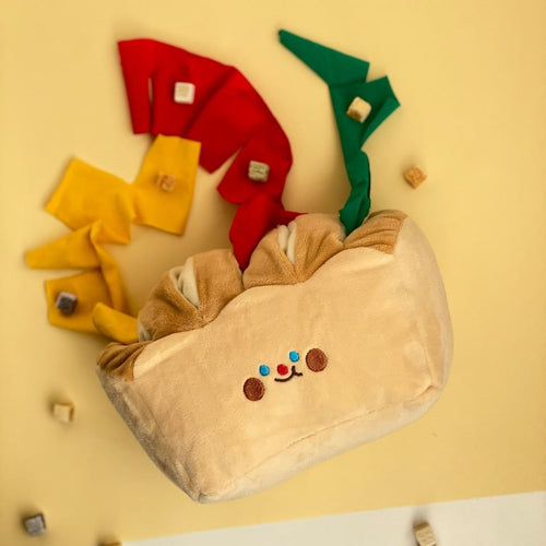 Cream plush dog sniffing pouch with cartoon face, with small faux food pieces attached