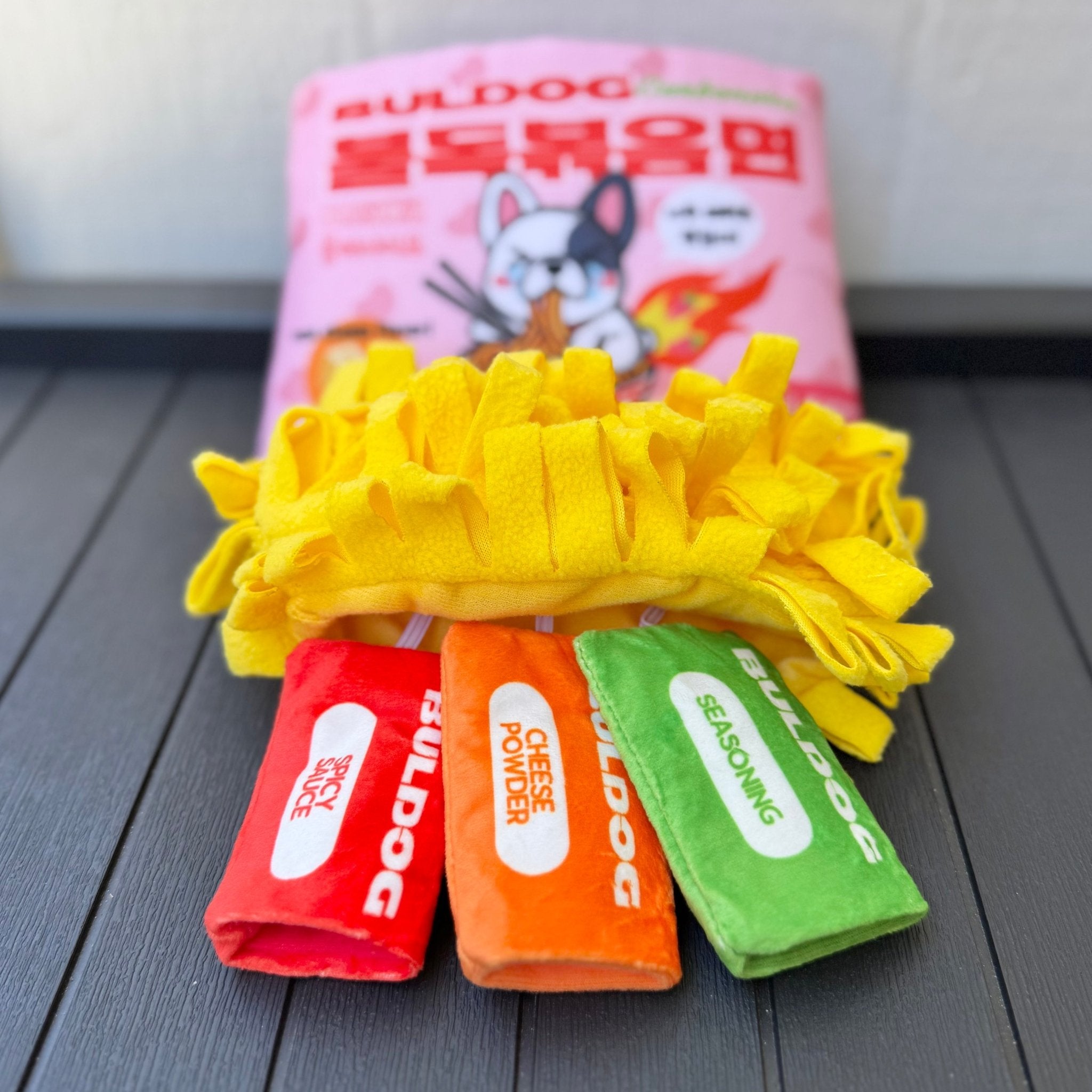 Yellow plush ramen noodle ring with red, orange, and green mini snack pouches