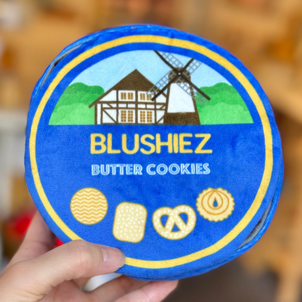 Round blue plush cookie-tin dog toy held in hand, BLUSHIEZ Butter Cookies graphic