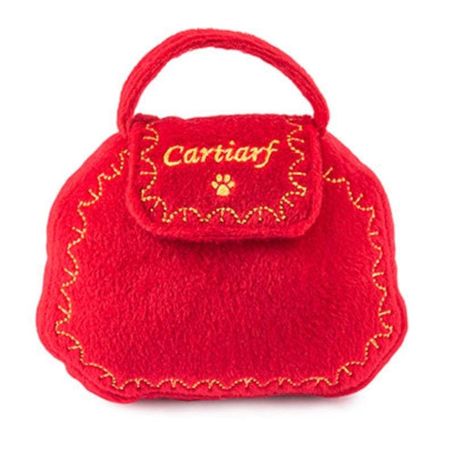 Red plush squeaky dog purse toy with handle, paw patch, and gold stitched edging