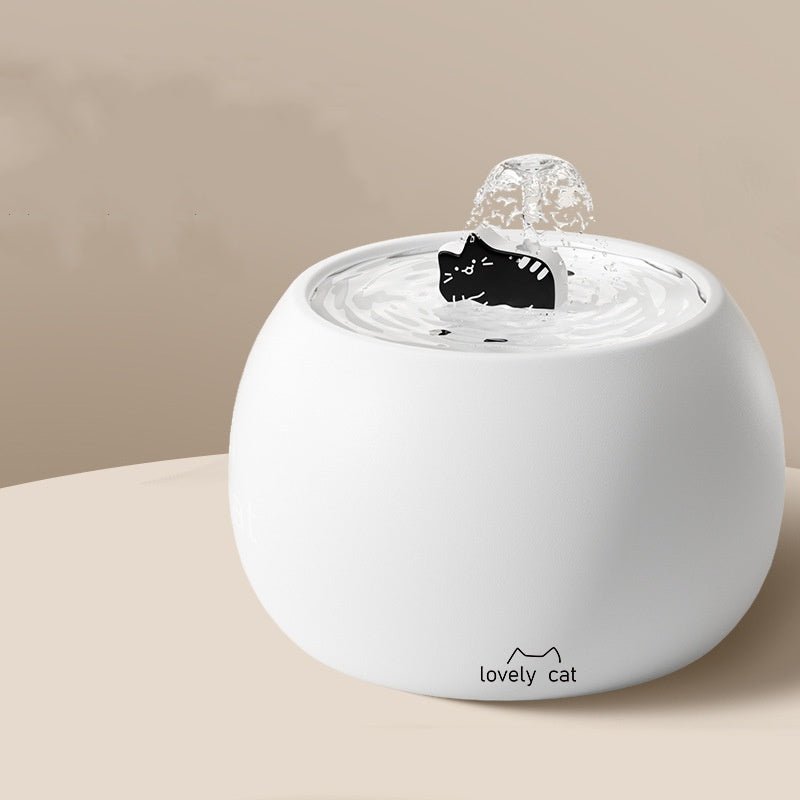White ceramic pet water fountain with cartoon cat spout and bubbling water dish