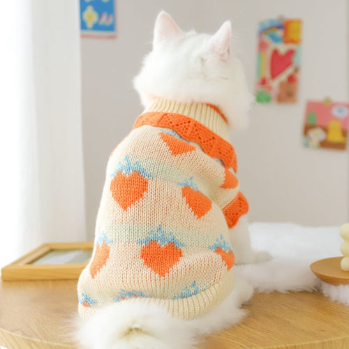 Back view cream knit cat sweater with orange neckline and blue/orange heart motifs