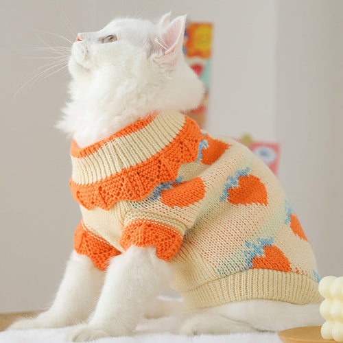 Cream knit cat sweater with orange collar and blue/orange heart pattern