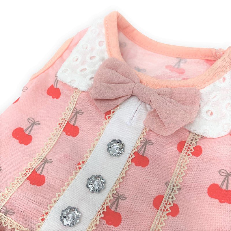 Close-up: pink cherry print pet dress with bow collar, lace edge, and rhinestone buttons