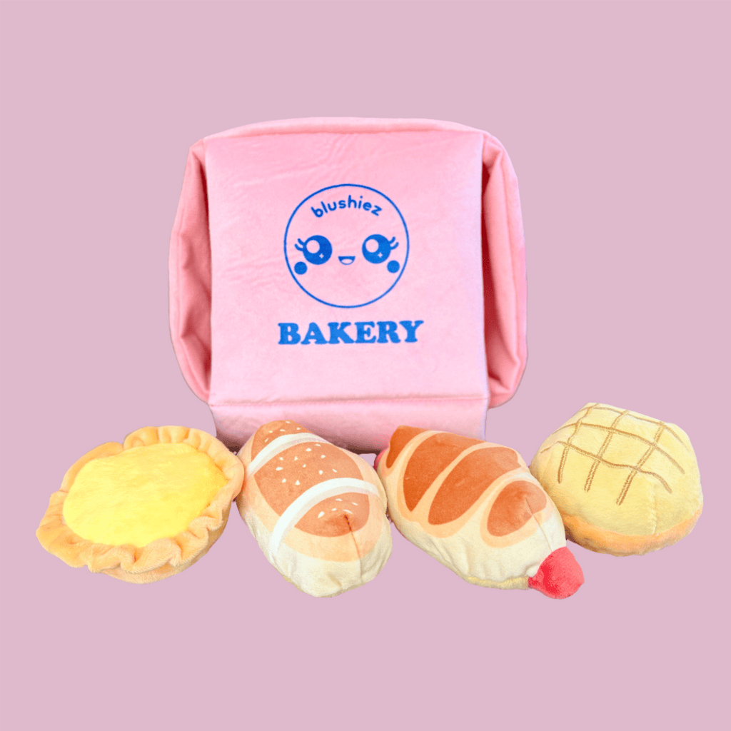 Pink plush bakery box dog toy with six stuffed pastry pieces