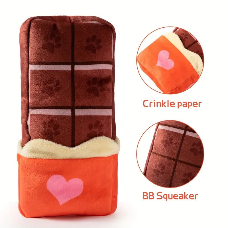Plush candy-bar dog toy with crinkle paper and squeaker; brown paw-print squares, orange heart