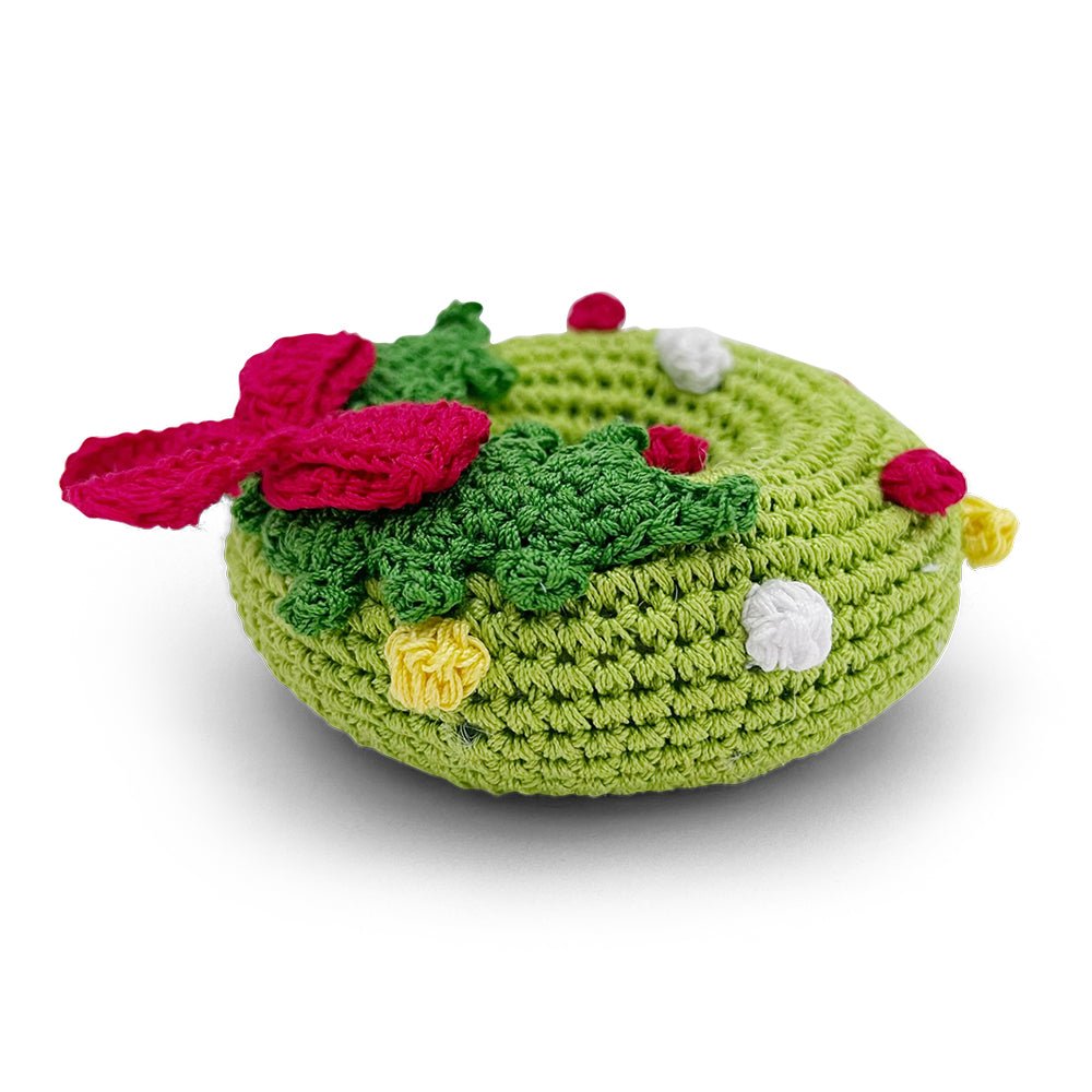 Crochet wreath toy with green round crochet, red ribbon, yellow flower, and white berries