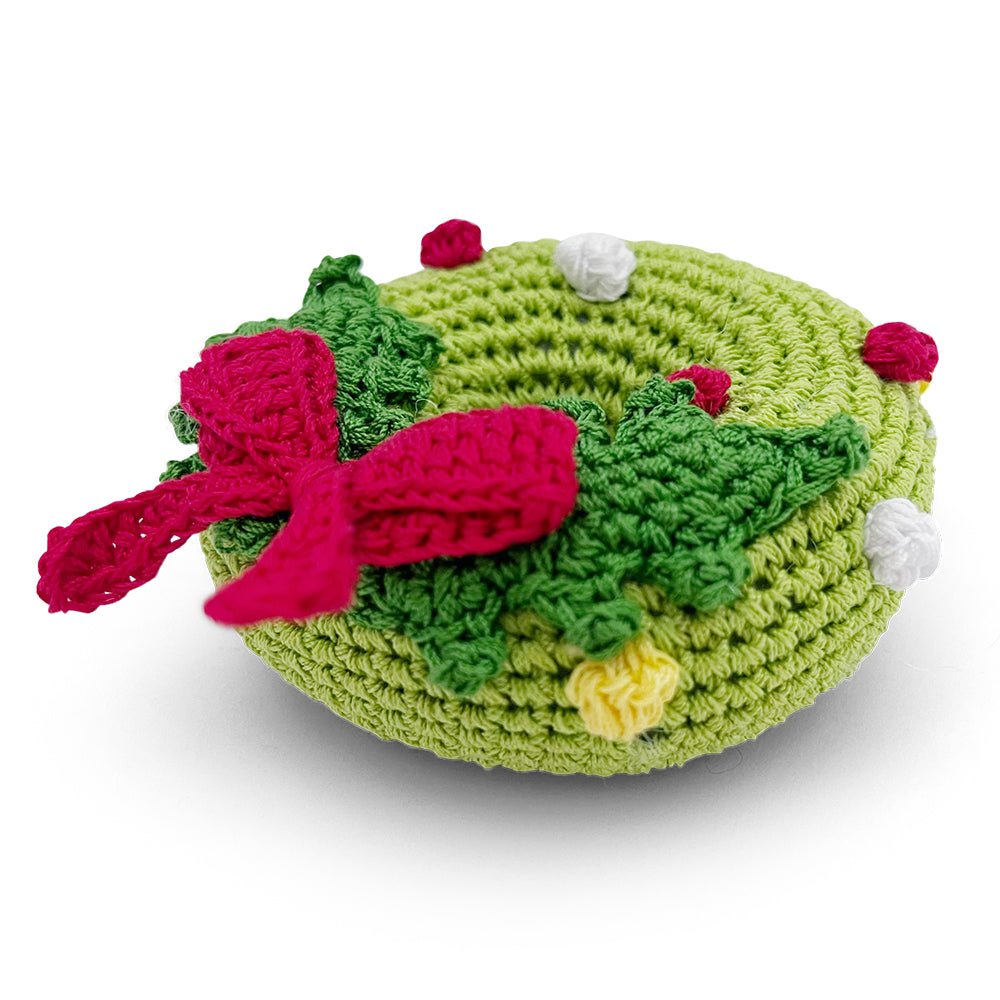 Crochet wreath toy, green round with red bow ribbon, red berries, and white accents