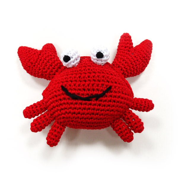 Red crocheted crab plush with claw legs, white-and-gray eyes, black smile