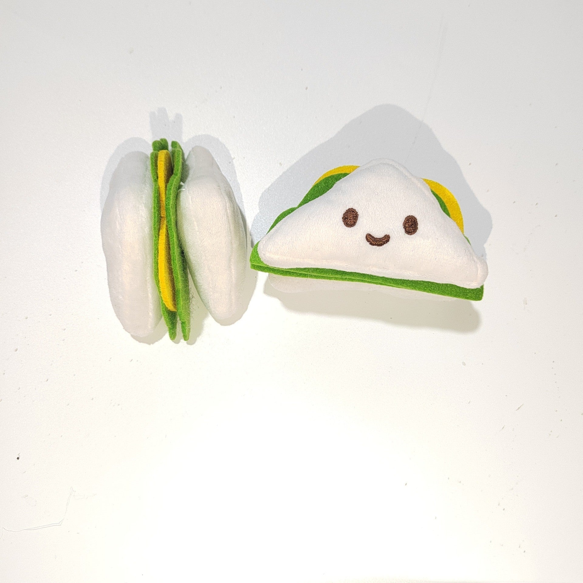 Plush taco-shaped pet sound toy with smiling face and green inner filling layers