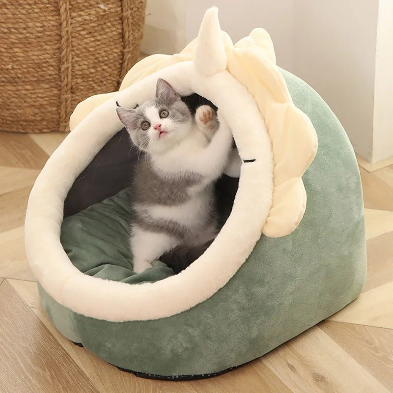 Plush cat cave bed with hanging ball toy, cream rim and green exterior, dark inner cushion