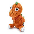 Crochet dinosaur toy, orange body with green spikes and white-and-black eyes, sitting pose