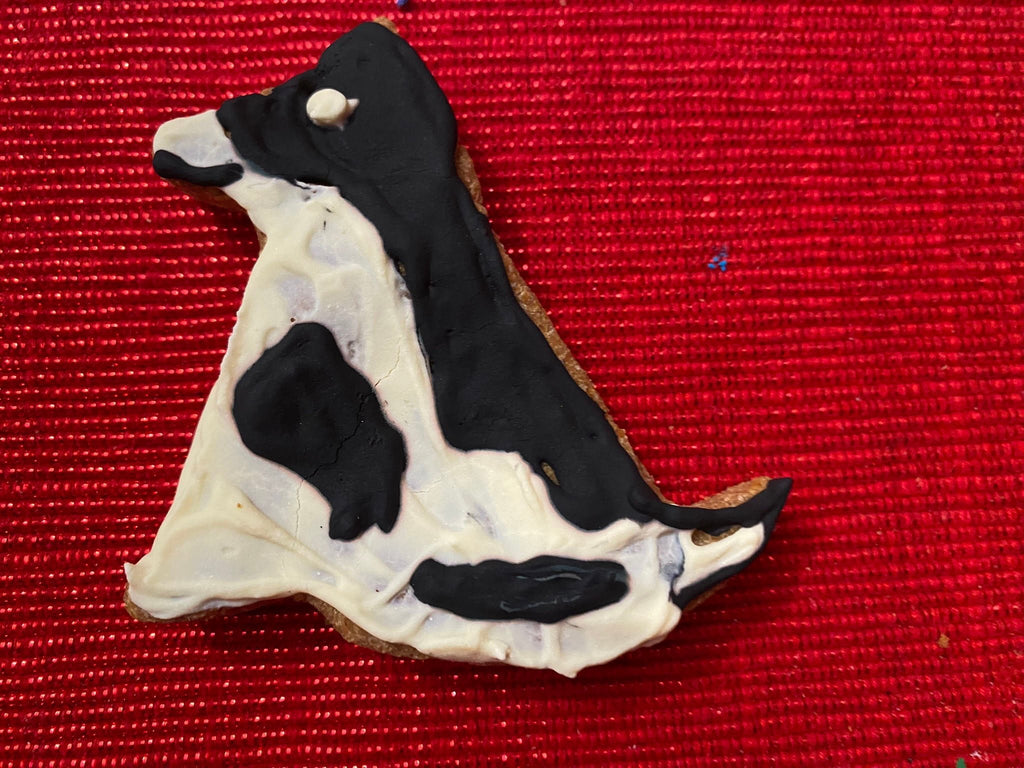 Duck-shaped dog cookie with black-and-white body and paw-print details