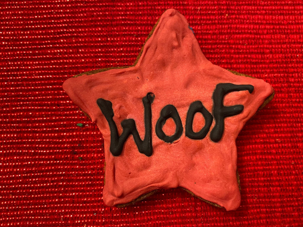 Star-shaped dog cookie with “Woof” text in black on orange-red