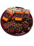 Assorted dog-themed cookies: black paw prints, orange bones, “Dog Mom” icing, sprinkles
