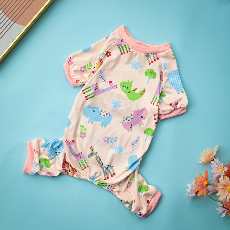 Dog pajama one-piece with dinosaur print, cream base and pink cuffs.