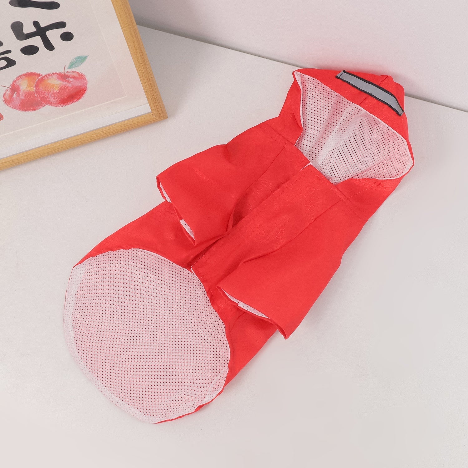 Red dog raincoat with hood and mesh inner panel, strap with black accent at top.