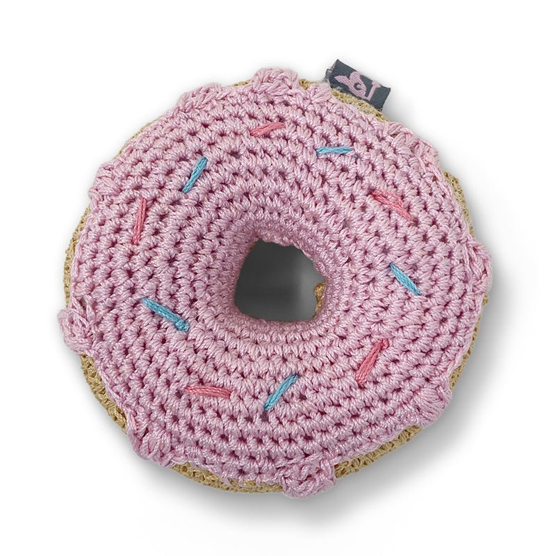 Crocheted pink donut toy with teal sprinkle stitches and a stitched center hole