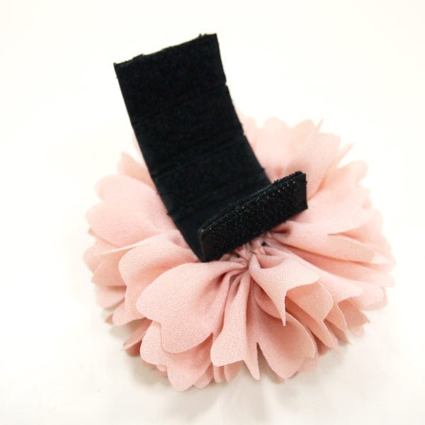 Pink fabric flower rosette with black fabric loop attachment.