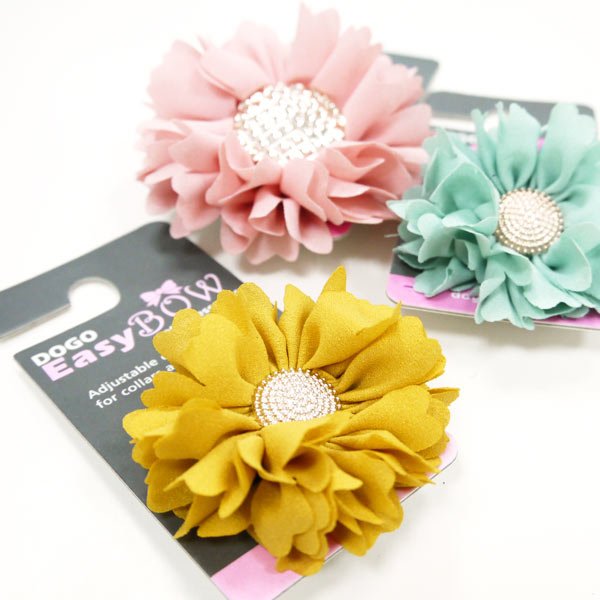 Three fabric flower rosettes in pink, yellow, and mint with rhinestone button centers.