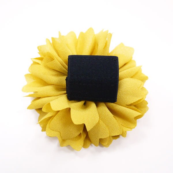 Yellow fabric flower rosette with black square backing.