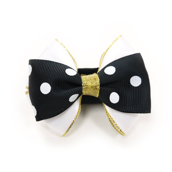 Black bow tie with white polka dots and gold ribbon tails