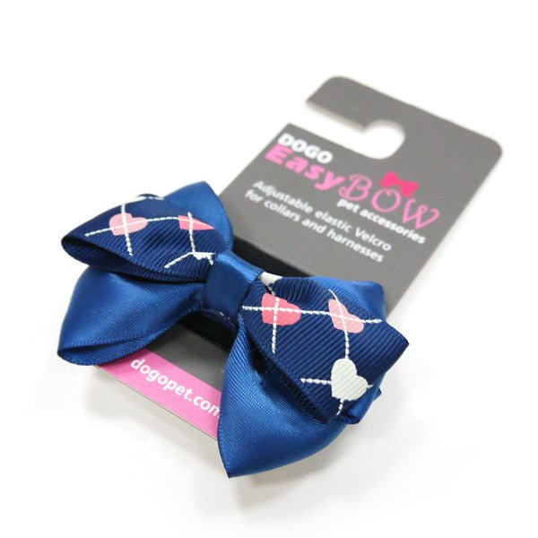 Blue bow tie with navy heart-and-ring pattern, shown on hanging card