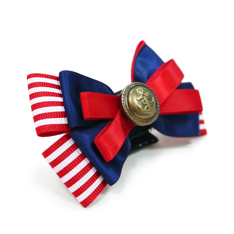 Nautical pet bow with red/white striped ribbon, dark blue loops, and gold button medallion