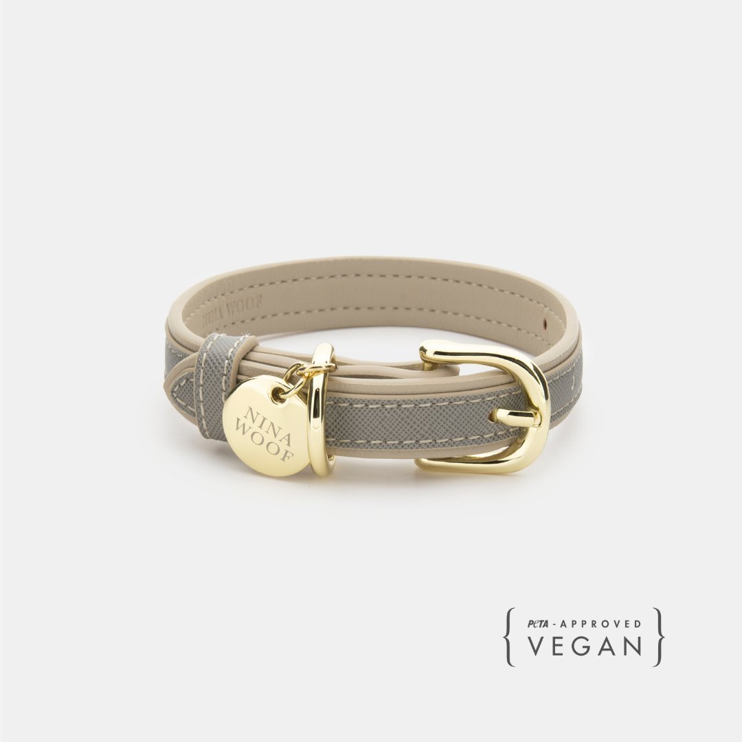 Light gray vegan leather dog collar with gold buckle and engraved round tag.