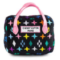 Black plush handbag-shaped dog toy with colorful star pattern and pink handles, CHEWYVUITON PARIS label