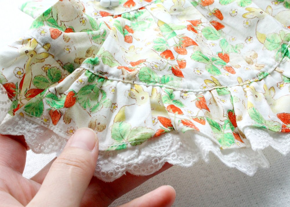 Close-up of floral rabbit-print pet dress skirt with tiered gathers and lace edge