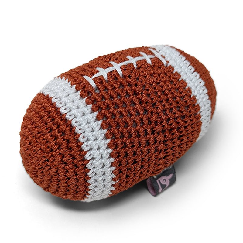 Crocheted football toy, brown-and-white panels with stitched laces, small fabric tag