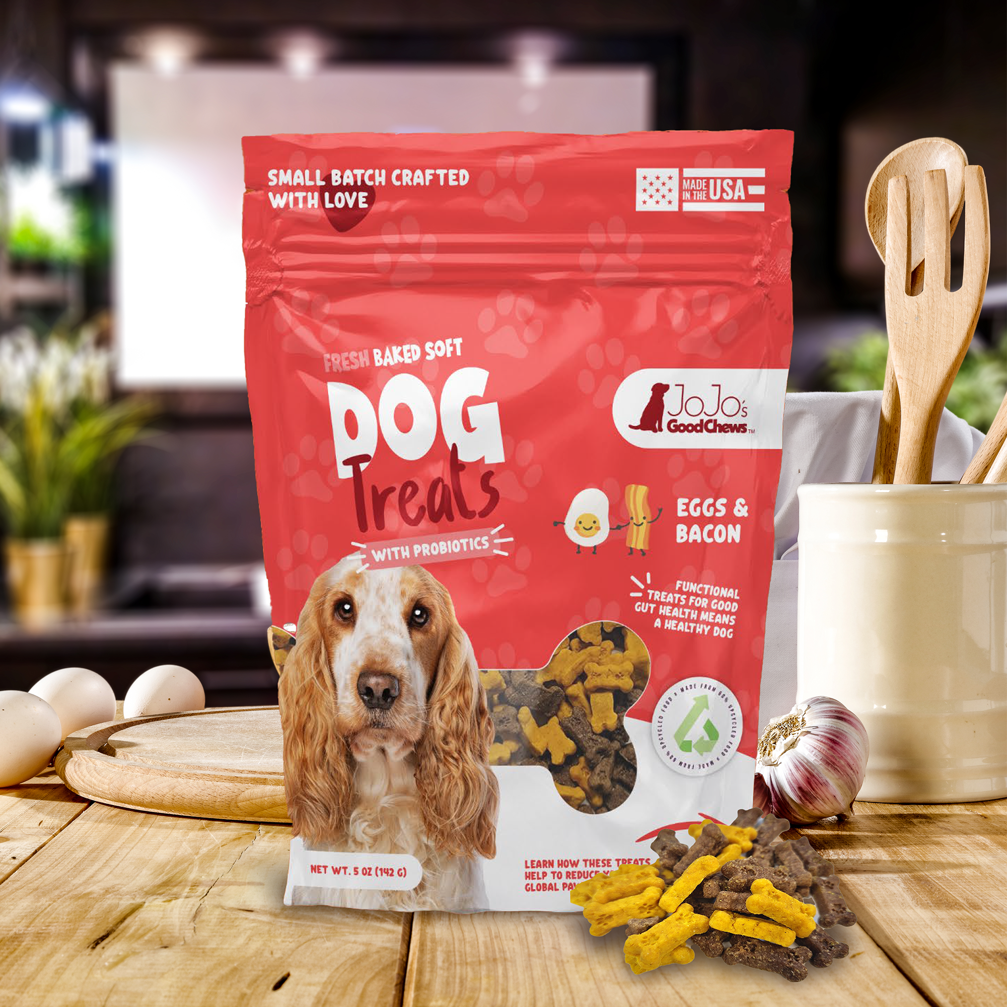 Red soft dog treat bag labeled eggs & bacon, with dog biscuits and eggs on table