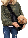 Black plush adjustable sling bag worn crossbody with small dog inside