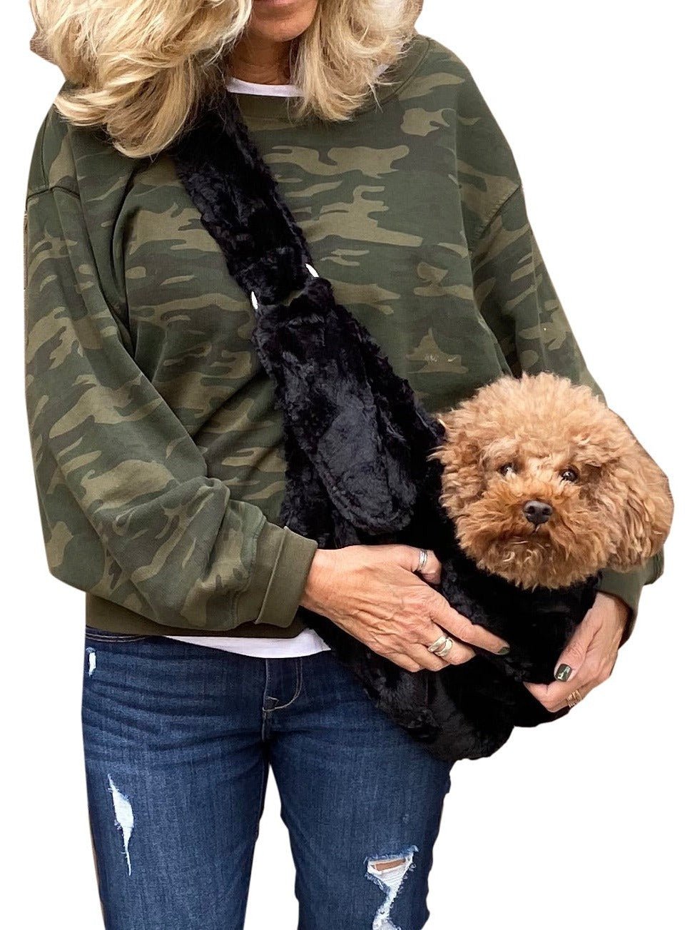 Black plush adjustable sling bag worn crossbody with small dog inside