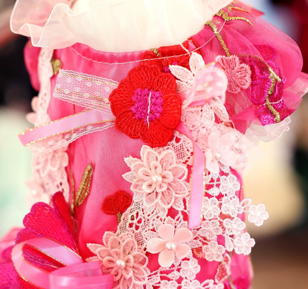 Hot-pink pet dress with lace yoke, large flower appliques, and ribbon bow sleeve