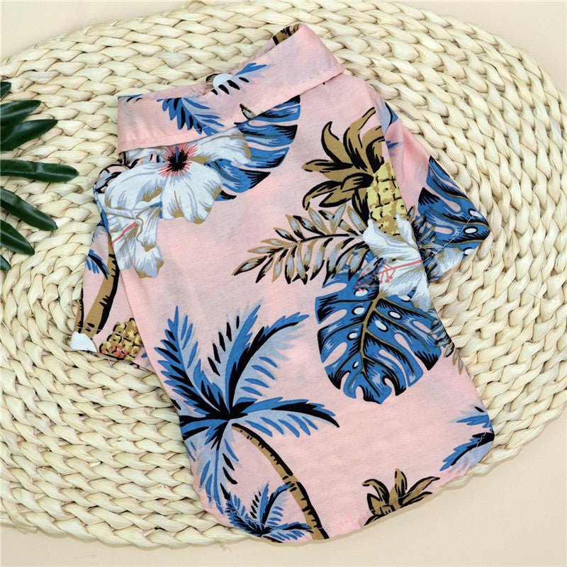 Small dog shirt in light pink with blue and green tropical leaf print.