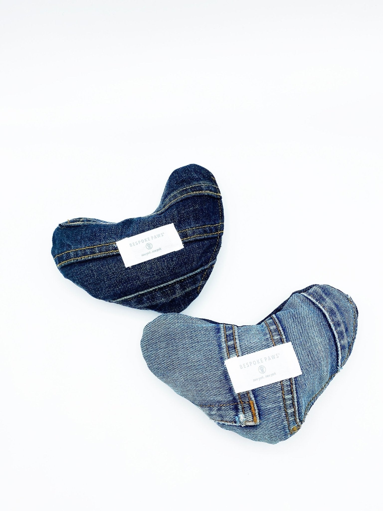 Two heart-shaped denim toys with raw-edge seams, dark and light blue washes