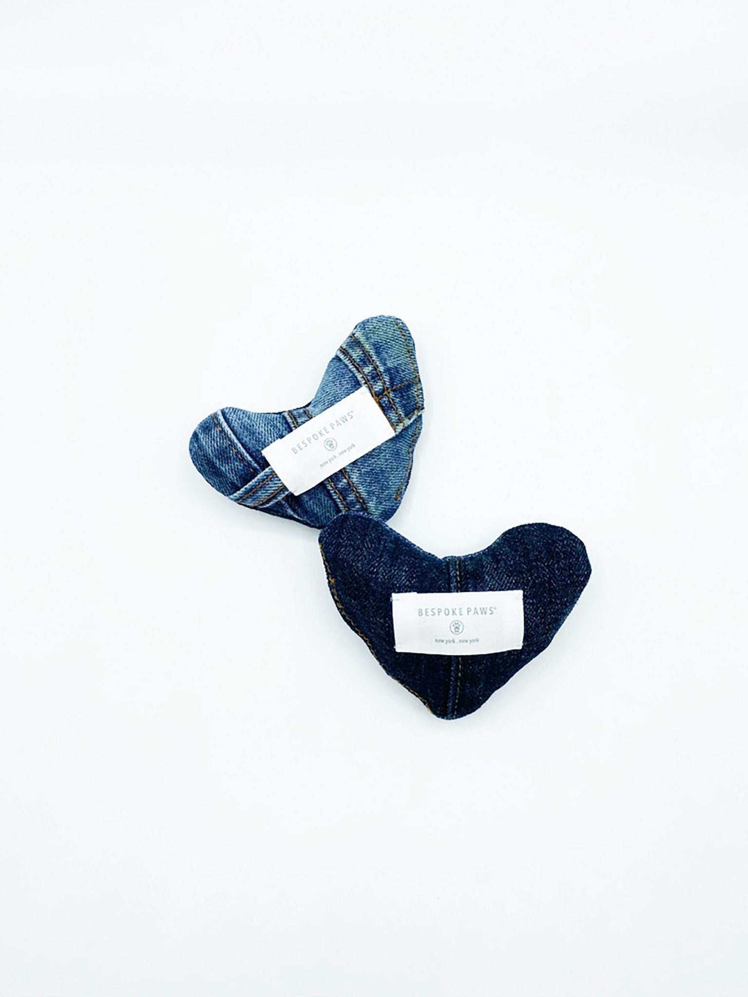Heart-shaped denim pet toy with patchwork panels in blue tones, white label tag